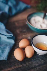 selective focus photography of three brown eggs near white ceramic bowl